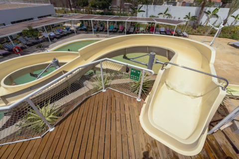 Tobogán amarillo y zona de piscina en Camping Costa del Sol Glamping Village, Andalucía, España.
