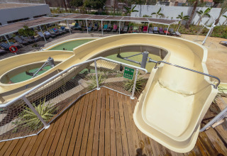 Gelbe Wasserrutsche und Poolbereich im Camping Costa del Sol Glamping Village, Andalusien, Spanien.