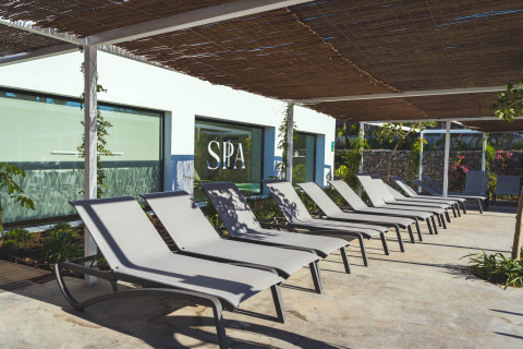 Area relax all'aperto al Camping Costa del Sol Glamping Village in Andalusia, Spagna, con lettini davanti alla spa.