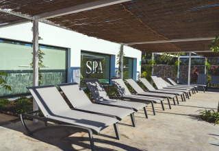 Zona de relajación exterior en Camping Costa del Sol Glamping Village en Andalucía, España, con tumbonas frente al spa.