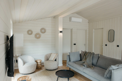 Lichte, moderne woonkamer in een Scandinavisch huisje bij Wilsumer Berge in Duitsland met comfortabele zitplaatsen.