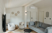 Gezellige en lichte woonkamer in Scandinavische stijl in een hut aan Wilsumer Berge, Duitsland, met comfortabele zetels.