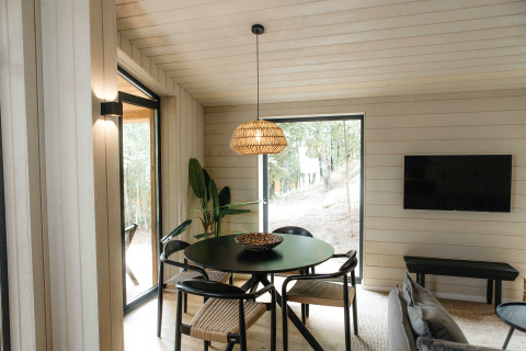 Moderne eetruimte bij Hill Top Scandi met sauna in Wilsumer Berge, grote ramen en uitzicht op de natuur.