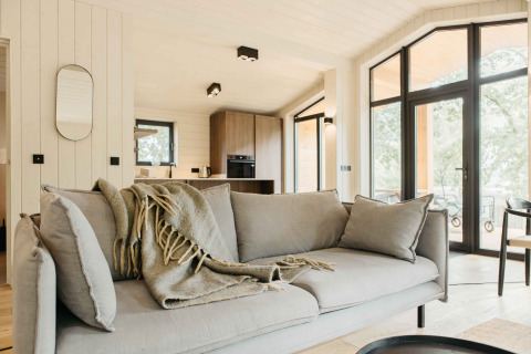 Moderne woonkamer in de Hill Top Scandi met Sauna cabin op Wilsumer Berge in Duitsland met grote ramen.