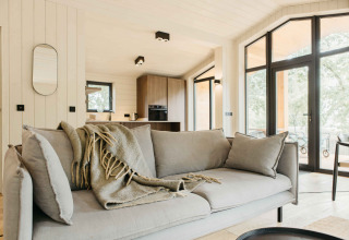Moderne woonkamer in de Hill Top Scandi met Sauna cabin op Wilsumer Berge in Duitsland met grote ramen.