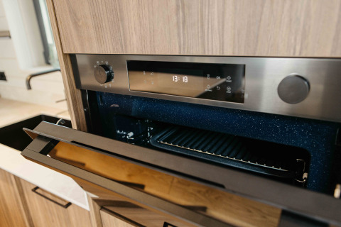 Moderne inbouwoven met open deur in de keuken van Hill Top Scandi met Sauna bij Wilsumer Berge, Duitsland.
