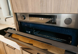 Moderne inbouwoven met open deur in de keuken van Hill Top Scandi met Sauna bij Wilsumer Berge, Duitsland.