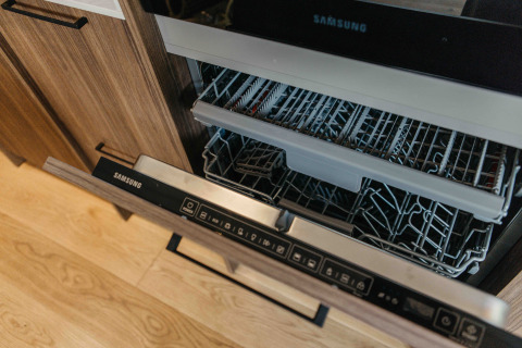 Een open Samsung vaatwasser in een modern keuken bij Hill Top Scandi met Sauna, Wilsumer Berge, Duitsland.