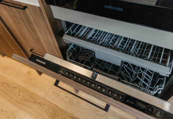 Een open Samsung vaatwasser in een moderne keuken bij Hill Top Scandi met Sauna, Wilsumer Berge, Duitsland.