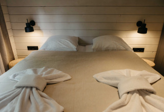 Knus bed met gevouwen handdoeken in de Hill Top Scandi met Sauna blokhut, Wilsumer Berge, Duitsland.