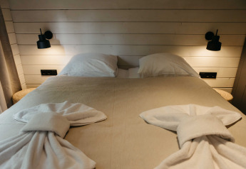 Knus bed met gevouwen handdoeken in de Hill Top Scandi met Sauna hut in Wilsumer Berge, Duitsland.
