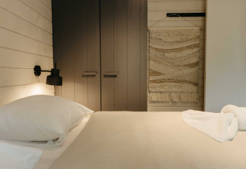 Modern slaapkamerinterieur bij Hill Top Scandi met Sauna, Wilsumer Berge in Duitsland, met wandtapijt en zachte tinten.