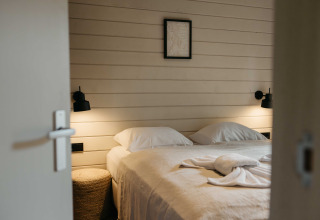 Knusse slaapkamer in Hill Top Scandi met Sauna, Wilsumer Berge, Duitsland, met tweepersoonsbed en lampen.