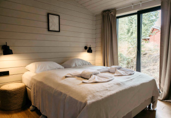 Chambre à Hill Top Scandi avec sauna à Wilsumer Berge, Allemagne, avec un lit double et de grandes fenêtres.