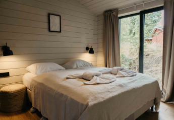 Slaapkamer in Hill Top Scandi met sauna op Wilsumer Berge, Duitsland, met dubbel bed en grote ramen.