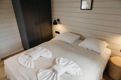 Moderne slaapkamer in Hill Top Scandi met Sauna bij Wilsumer Berge, Duitsland, stijlvol opgemaakt bed.