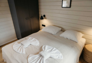 Moderne slaapkamer in Hill Top Scandi met Sauna bij Wilsumer Berge, Duitsland, stijlvol opgemaakt bed.