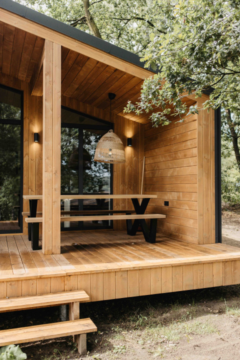 Houten veranda met bank en hanglamp bij Hill Top Scandi met Sauna, Wilsumer Berge, Duitsland.