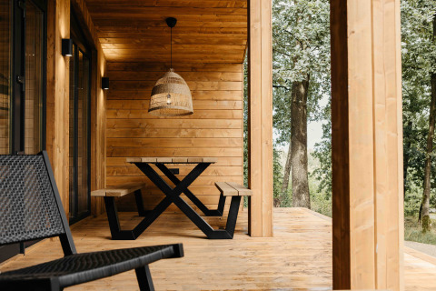 Houten veranda bij Hill Top Scandi met Sauna in Wilsumer Berge, Duitsland, met bankjes en hanglamp.