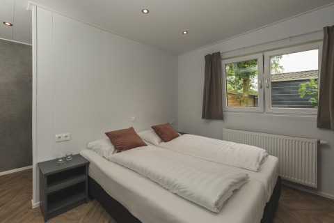 Camera moderna presso River Lodge 'Wellnesshuus' al Holiday Park Mölke, Paesi Bassi, con letto matrimoniale.