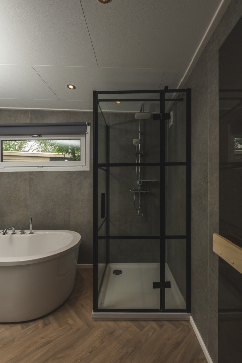Salle de bain moderne avec douche vitrée et baignoire au River Lodge 'Wellnesshuus' à Mölke, Pays-Bas.