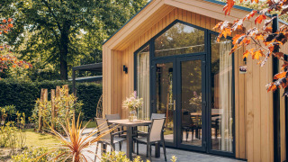 Tiny Lodge avec bain à remous, façade bois contemporaine, terrasse conviviale et environnement verdoyant.