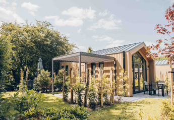 Casa pequeña y moderna Tiny Lodge en Veluwepark de Bosgraaf, Países Bajos, rodeada de naturaleza y jardín.