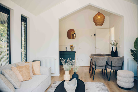 Interior luminoso y moderno de una Tiny Lodge en Veluwepark de Bosgraaf, Países Bajos, con diseño acogedor.