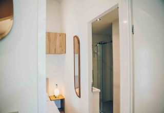 Interior moderno en Tiny Lodge con baño y dormitorio en Veluwepark de Bosgraaf, Países Bajos.