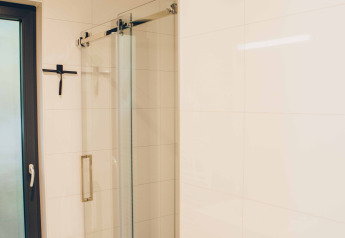 Douche moderne avec porte en verre à Tiny Lodge, Veluwepark de Bosgraaf avec jacuzzi, Pays-Bas.