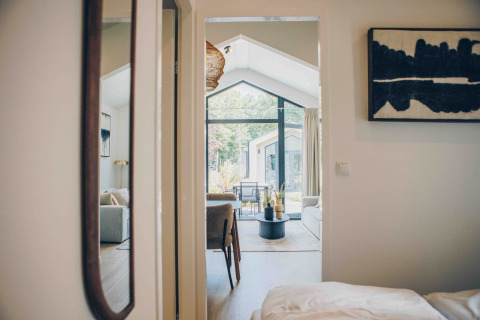 Vue intérieure de Tiny Lodge avec décoration moderne et grandes fenêtres au Veluwepark de Bosgraaf, Pays-Bas.