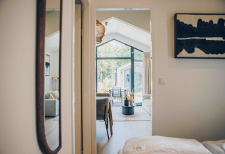 Vue intérieure de Tiny Lodge avec décoration moderne et grandes fenêtres au Veluwepark de Bosgraaf, Pays-Bas.