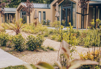 Tiny Lodge confortable avec bain à remous au Veluwepark de Bosgraaf, Pays-Bas, entourée de verdure paisible.