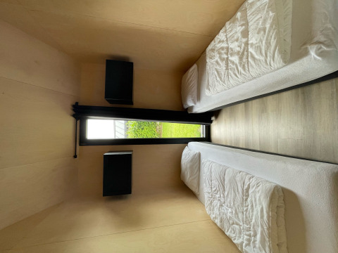 Chambre moderne avec deux lits simples et vue sur jardin dans Tiny house XL au Holiday park Eigen Wijze.