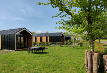Moderne Tiny Houses mit schwarzen Dächern und Holzverkleidung im Holiday Park Eigen Wijze, Niederlande.