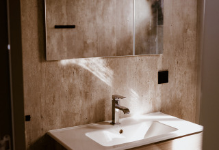 Lavandino moderno con mobile in legno e specchio nel Tiny house XL al Holiday park Eigen Wijze, Paesi Bassi.