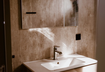 Modernes Badezimmer mit Holzwaschtisch, Spiegel und Waschbecken im Tiny house XL im Holiday park Eigen Wijze, Niederlande.