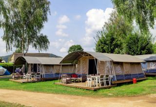 Immagine di tende moderne con terrazze in legno e mobili da esterno in un campeggio stile lodge immerso nella natura.