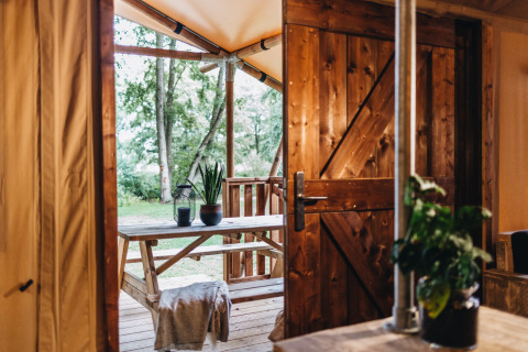 Gezellige houten veranda met tuinzicht, gezien door een open deur bij Beerze Bulten vakantiepark in Overijssel.
