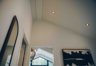 Modern interieur in de Tiny Lodge met hoog plafond en kunst bij Veluwepark de Bosgraaf, Nederland.
