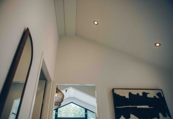 Arredo moderno nella Tiny Lodge con soffitto alto e opera d'arte al Veluwepark de Bosgraaf, Paesi Bassi.