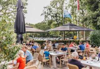 Gezellige vakantiegasten genieten samen op het zonnige terras van Beerze Bulten in Overijssel, Nederland.