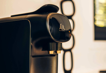Sort Philips kaffemaskine på et lodgebord med moderne dekoration i baggrunden, indbydende stemning.