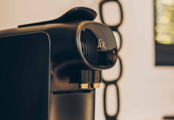 Sort Philips kaffemaskine på et lodgebord med moderne dekoration i baggrunden, indbydende stemning.