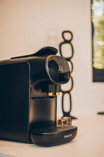 Schwarze Philips-Kaffeemaschine auf einer Lodge-Theke mit modernem Dekor im Hintergrund, warme Atmosphäre.