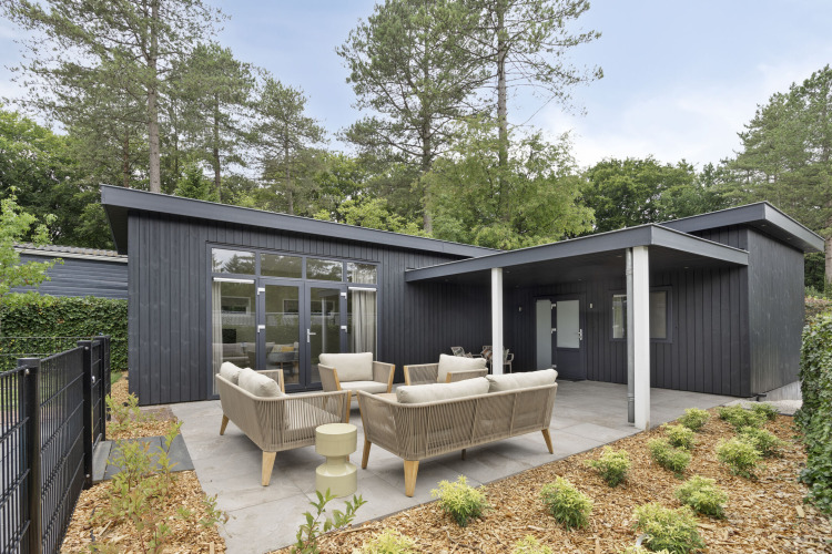 Moderne Lodge mit Terrasse, Outdoor-Sitzbereich und Waldkulisse auf De Thijmse Berg in den Niederlanden.
