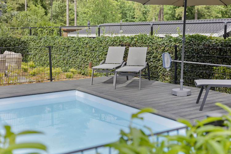Liegestühle und Sonnenschirm an einem privaten Pool der 10-Personen-Lodge, De Thijmse Berg, Niederlande.