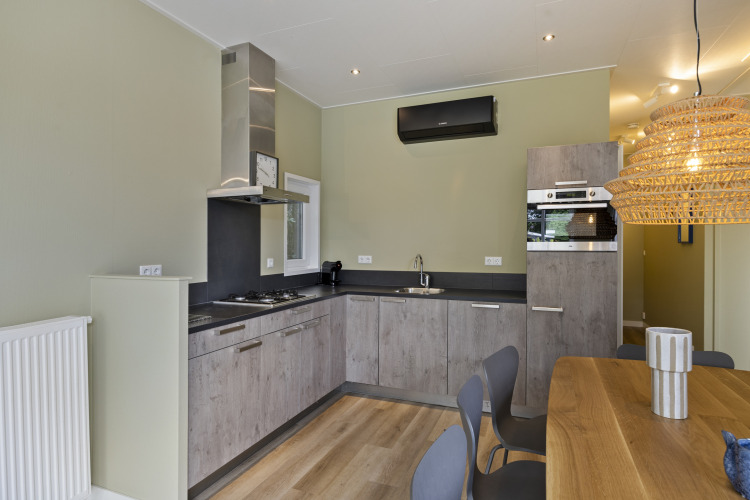 Moderne Küche in einer Lodge am De Thijmse Berg, Niederlande, mit Holzmöbeln und Esstisch.