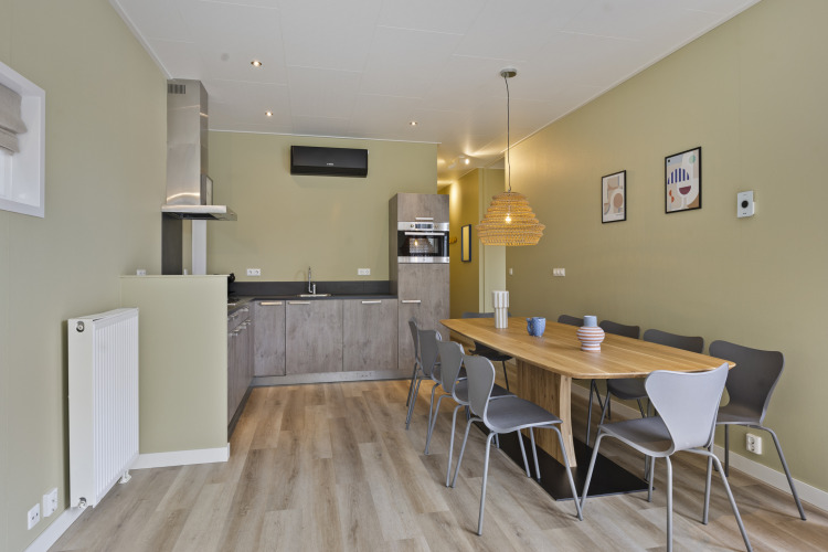 Essbereich mit modernem Küchenbereich in einer 10-Personen-Lodge mit stilvollem Holztisch bei De Thijmse Berg.