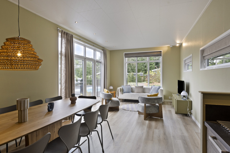 Wohn- und Essbereich in einer 10-Personen-Lodge mit großen Fenstern und modernem Design, De Thijmse Berg, Niederlande.